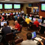 Engaged bettors analyzing kèo nhà cái 5 in a vibrant sports betting venue with screens