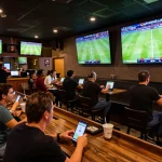 Patrons enjoying live sports betting at Keonhacaii88's vibrant sports bar, cheering for their teams